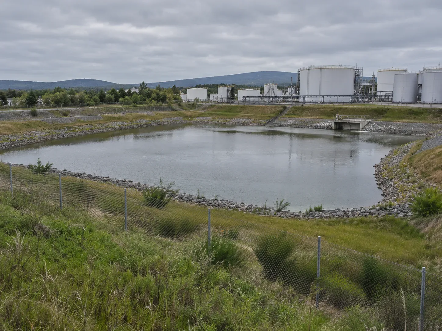 Bassin de rétention et limites extérieures d’un site industriel.